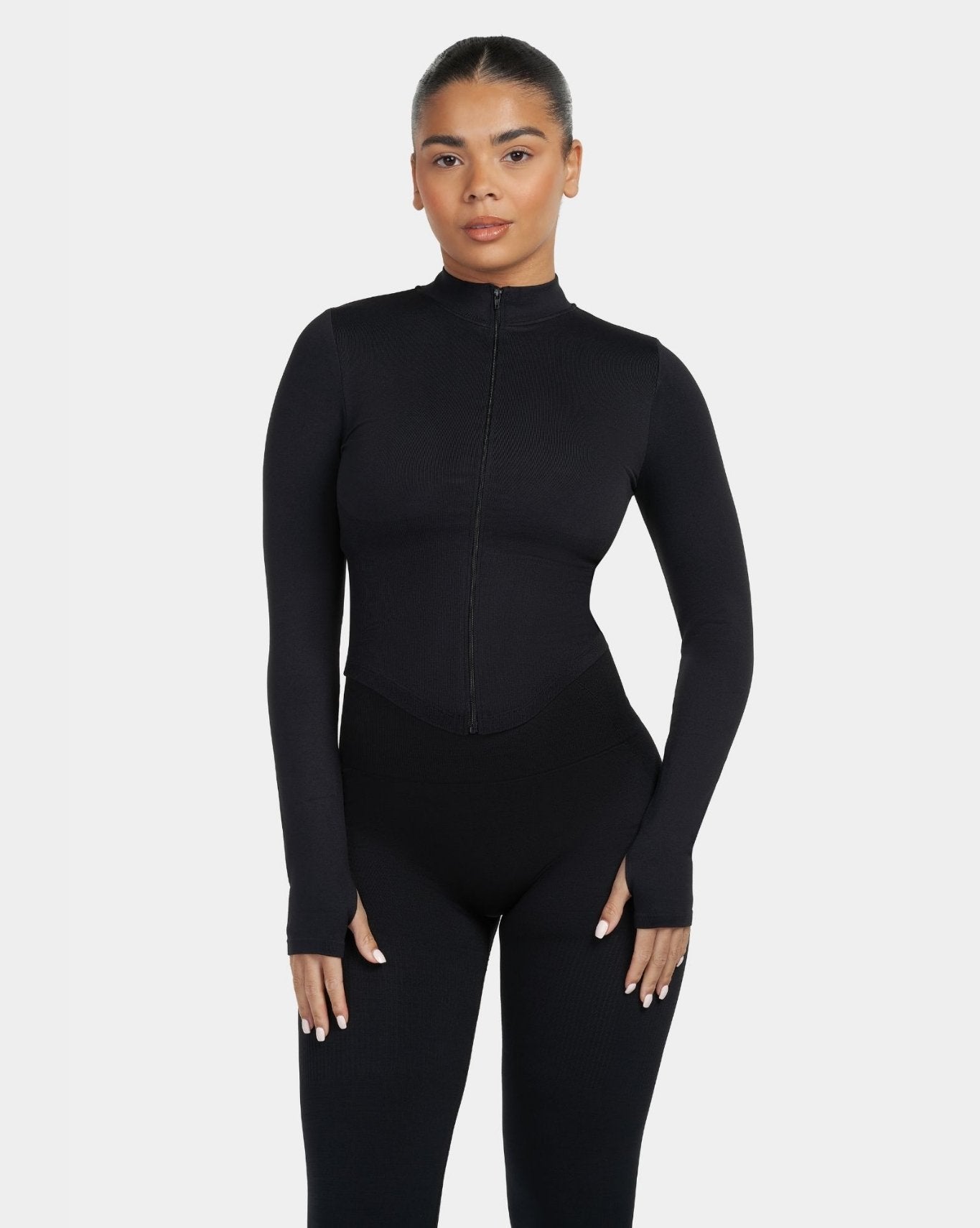 Person wearing a black bodysuit on a white background